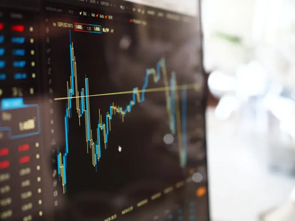 Tela de monitor exibindo gráfico de candlesticks do mercado de câmbio